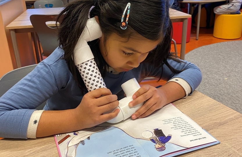 girl reading book out loud for herself